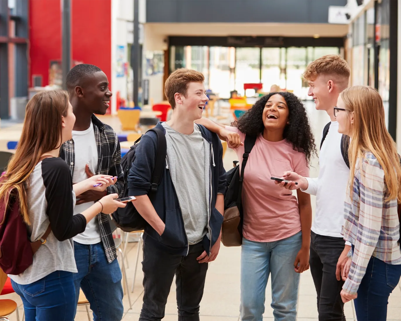 Group of students talking and laughing together on a college campus