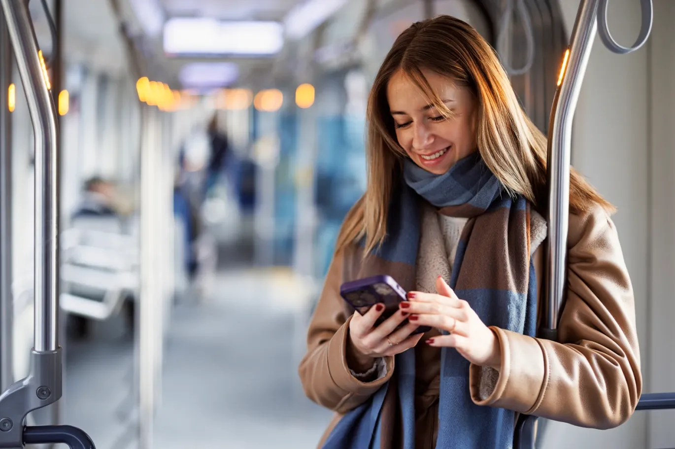 A girl using her phone while travelling on the metro