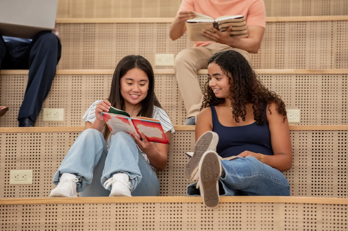Two students sitting on campus steps studying together and talking