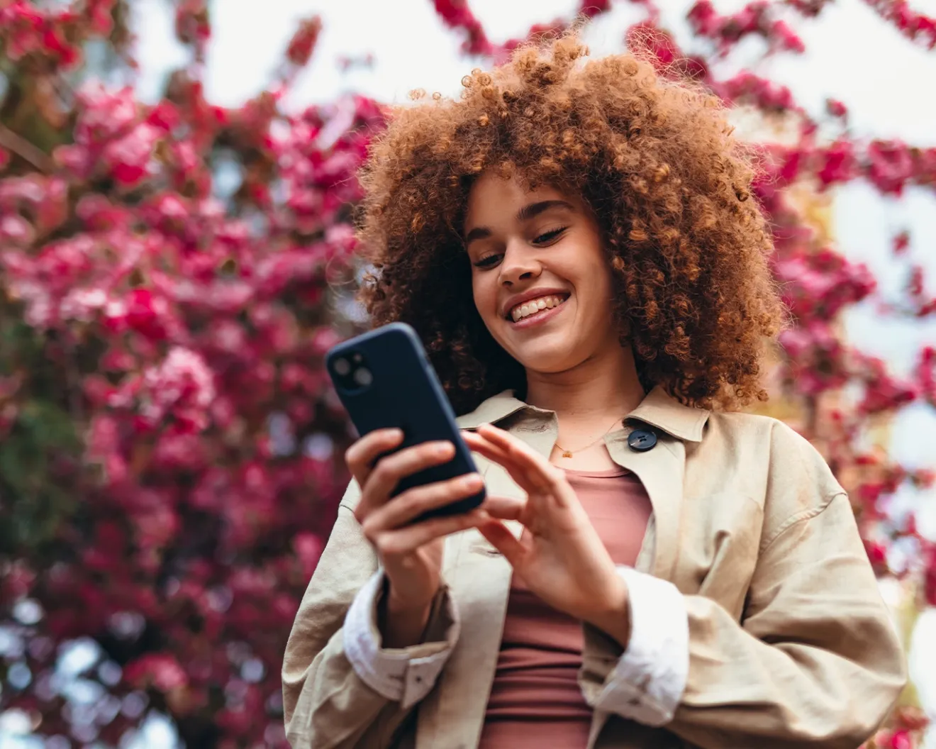 Girl smiling in front of blooming tree