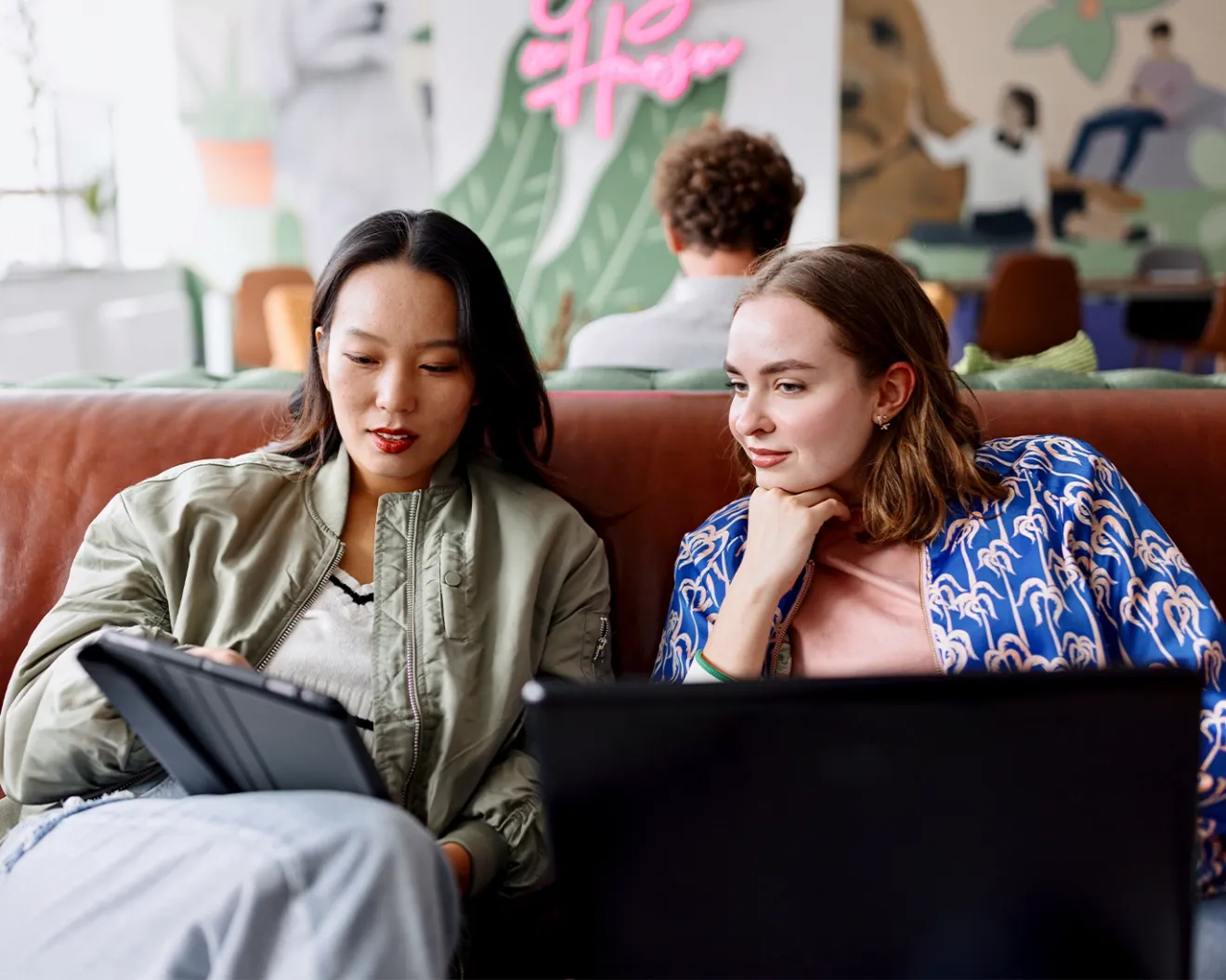Friends sitting on a couch with laptops